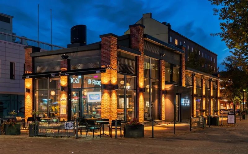 Ravintola Borgin tiilijulkisivu ja valaistu terassi Porin Eetunaukiolla iltahämärässä